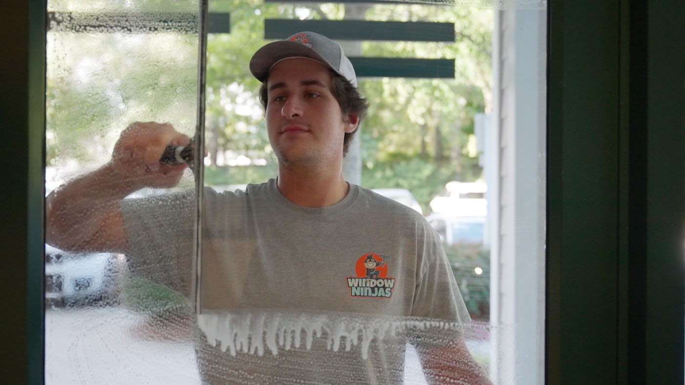 A Window Ninjas team member cleaning a window. 